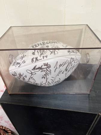 A Wilson NFL football autographed by multiple individuals in a case 1