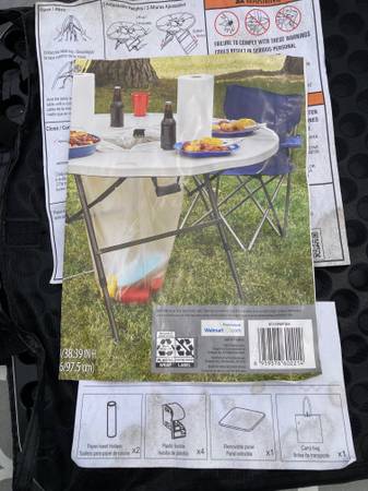 back yard or camping table with trash holder in center . 1