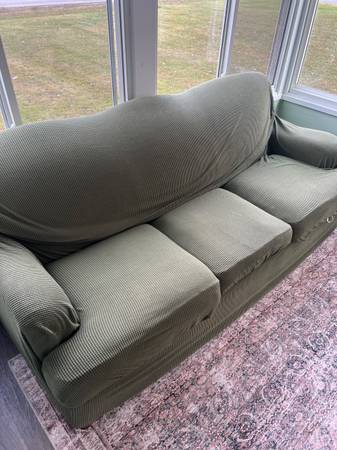 Brown couch with green slip cover 1