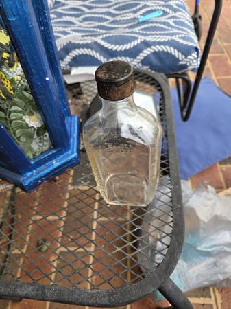 Vintage clear glass bottle has embossed measurements on side. Base is marked wit 1
