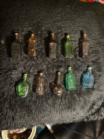 Vintage tiny bottles with varius companies listed 1