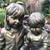 An enchanting siblings reading on bench garden statue 2 thumbnail
