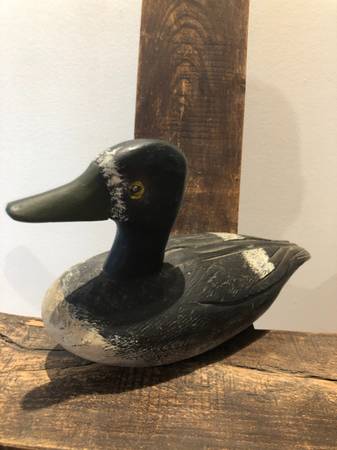 A Duck decoy, specifically a vintage, handpainted, and carved wooden 1