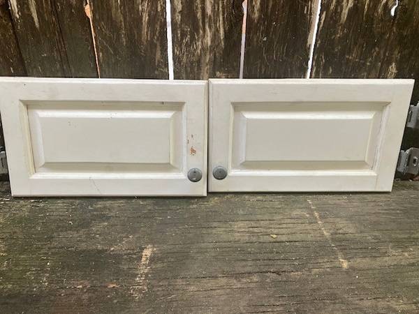 Pair of small white cabinet doors with hinges and knobs 1