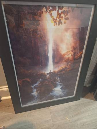 This framed wall art print features a dramatic, glowing waterfall 1
