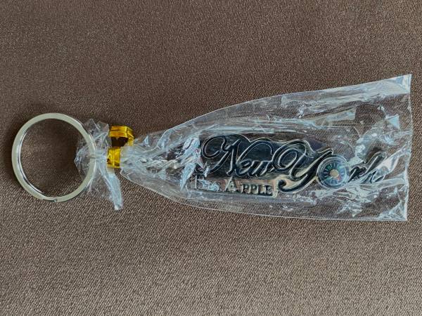 Big Apple themed Keychain in packaging with compass in the "O". "NEW" 1
